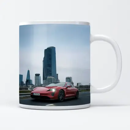 Red Porsche Taycan Driving Through City Skyline