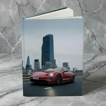 Red Porsche Taycan Driving Through City Skyline