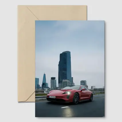 Red Porsche Taycan Driving Through City Skyline