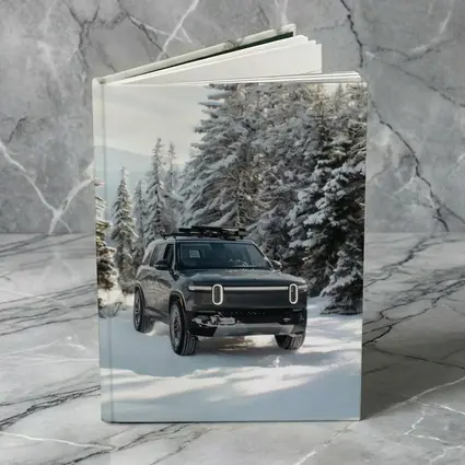 Rivian R1S Dark SUV Snowy Forest Trail